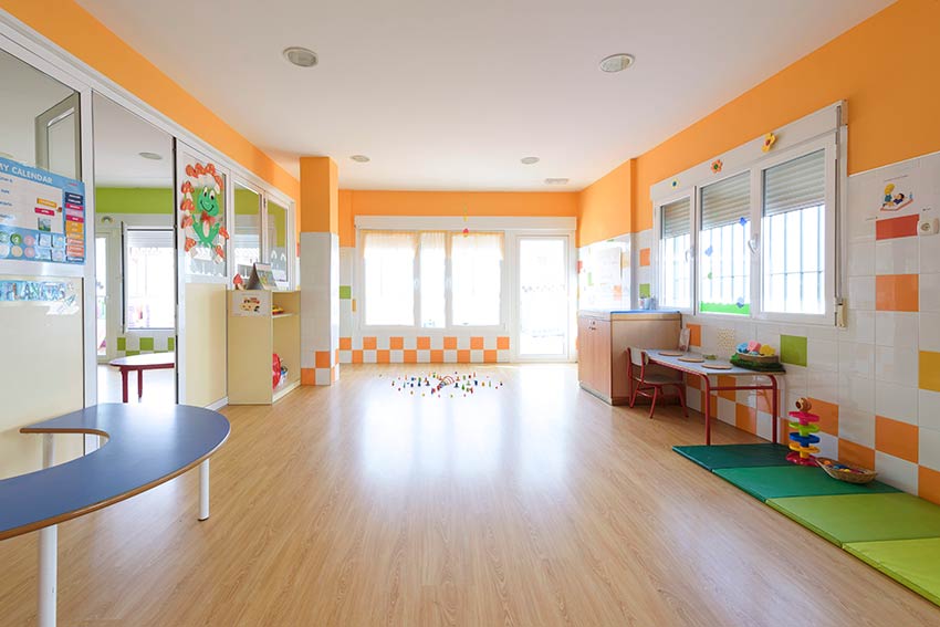 Vista desde otro ángulo del aula Planetas con las paredes de color naranja del Centro Infantil El Barrio