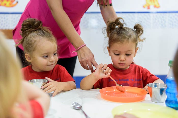 Niñas comiendo en el comedor de la escuela infantil en Monachil