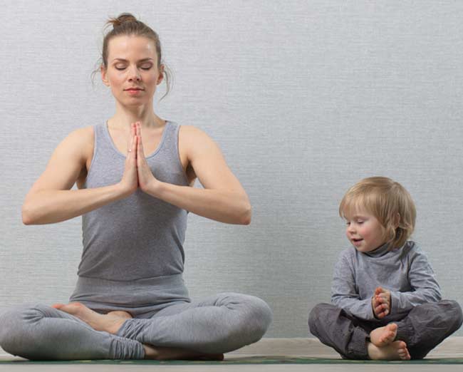 Mujer y niño pequeño practicando yoga